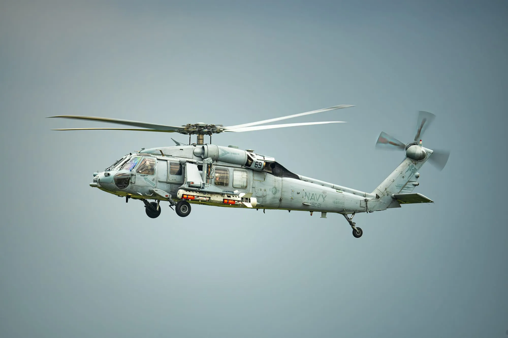 A grey military helicopter in flight