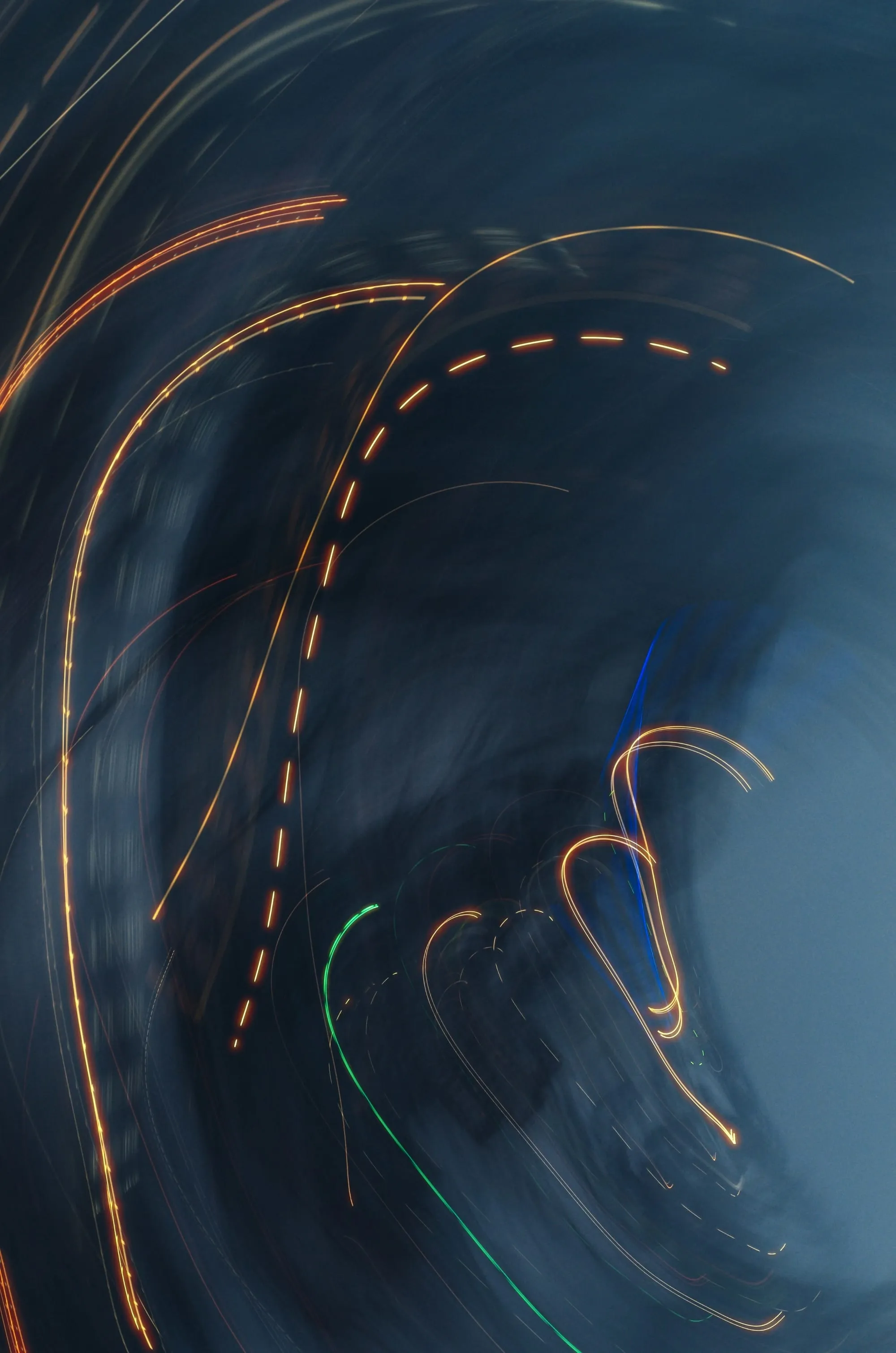 Long-exposure light trails curving through the dark in overlapping arcs